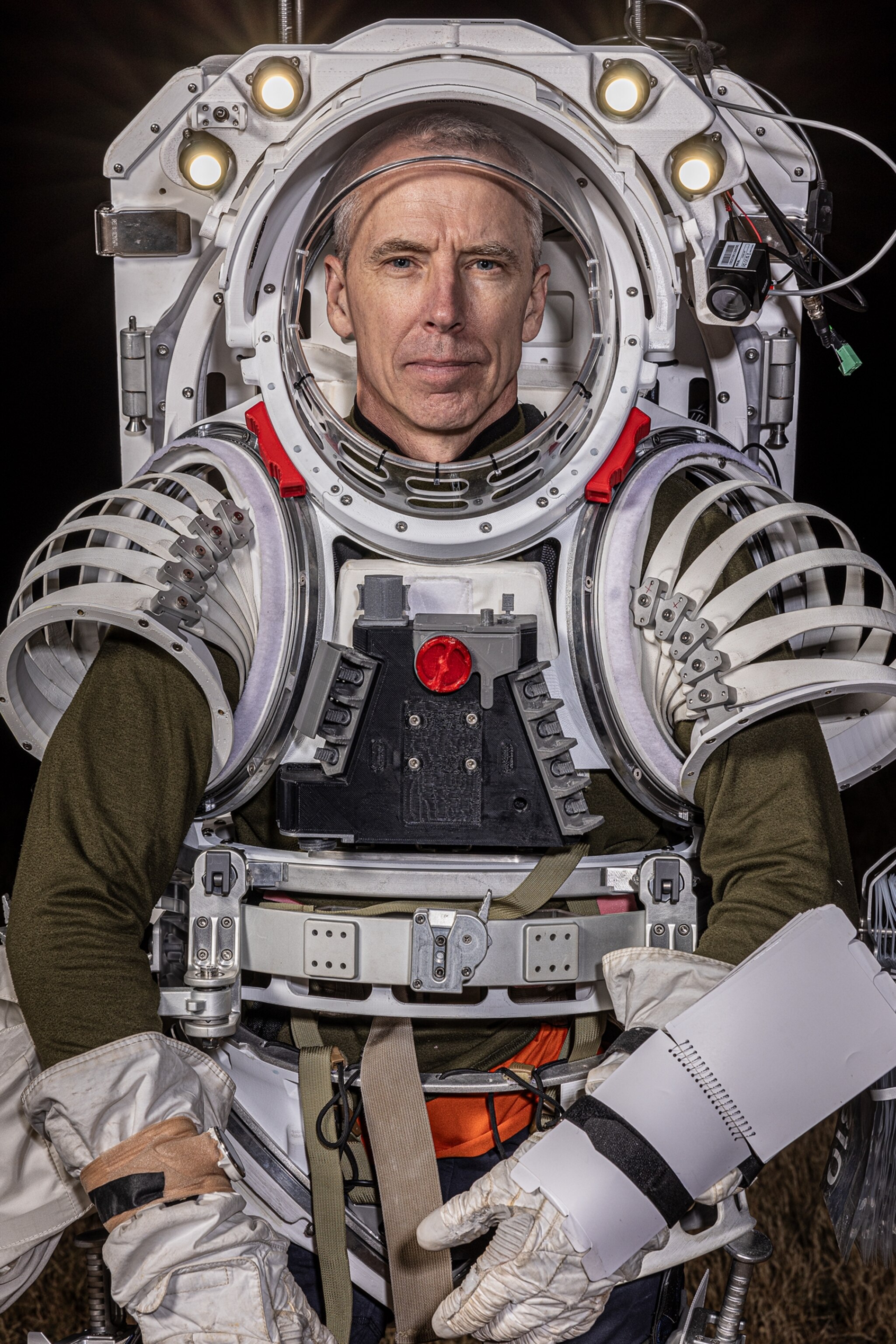 Sitting portrait of a man in full space suit.