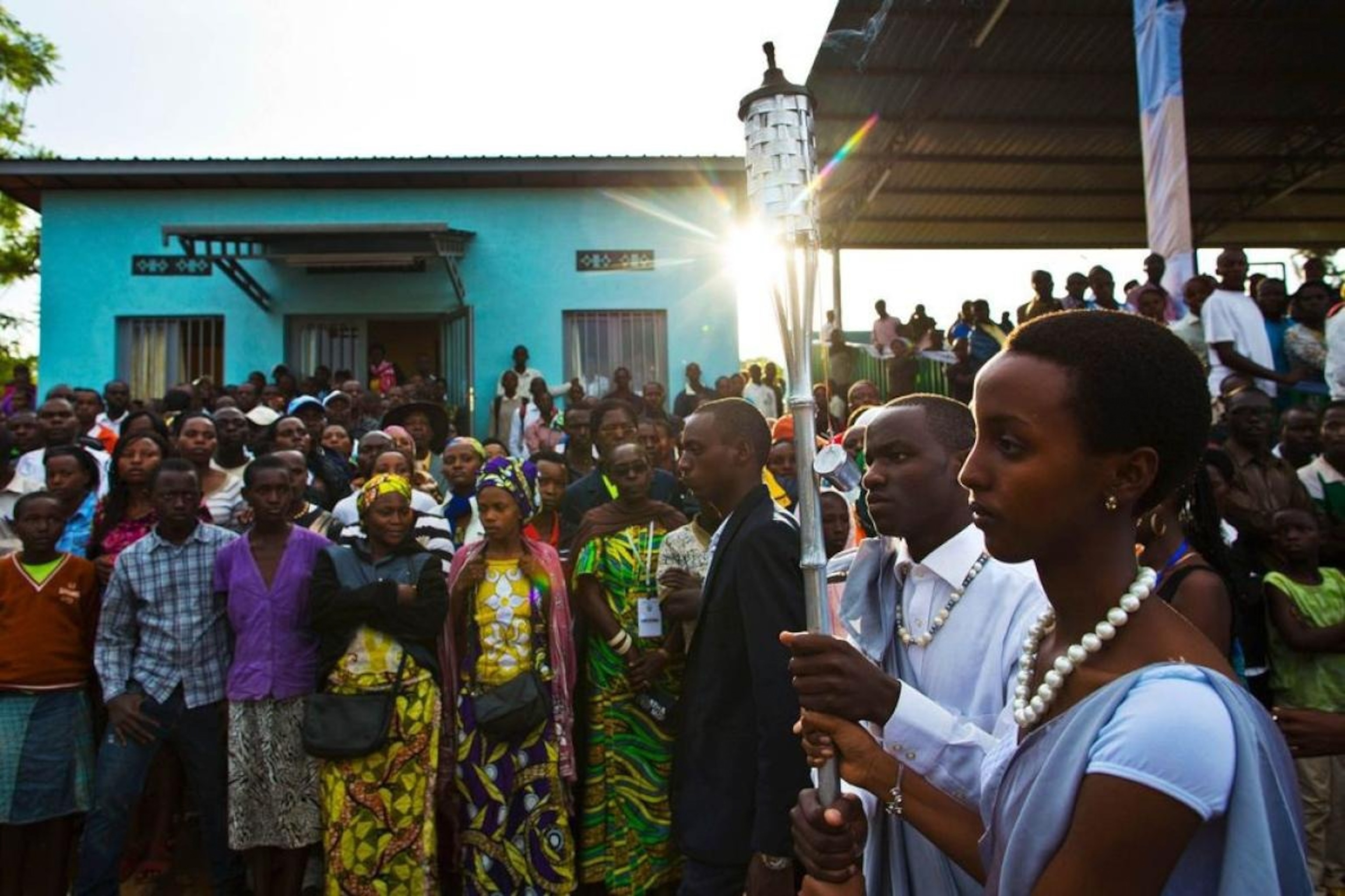 Rwandans carry a Flame of Remembrance past a crowd to commemorate the 20th anniversary of the Rwandan genocide.