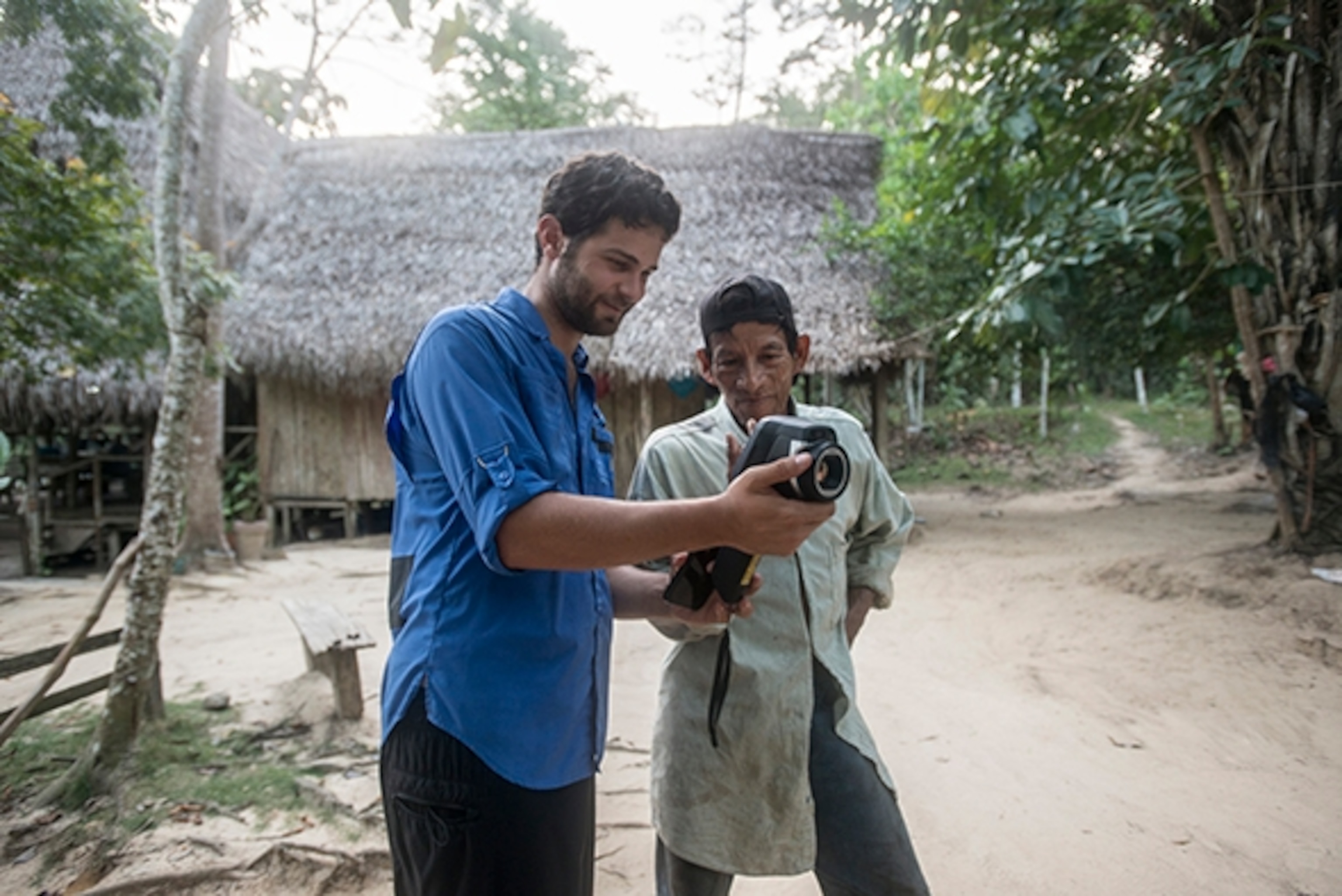 Downriver from Mayantuyacu, lies the second Amazonian shamanic community—Santuario Huistín. Both communities have been integral in supporting the scientific work done at the Boiling River. The locals have been curious about the research and excitement to gain a better understanding of their sacred river. Here, Andrés shows a Huistín community member how to use a thermal camera; Photograph by Devlin Gandy