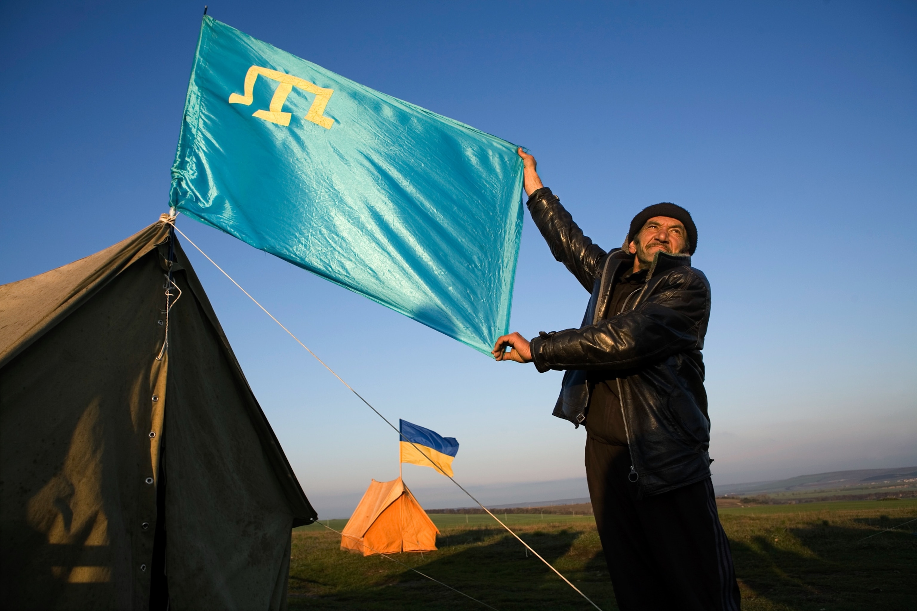 Crimean Tatars holding flags during a rally.