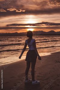 Stock Image: Woman enjoying freedom on beach in sunset