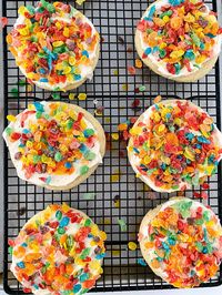 This colorful cookie is a copycat recipe for Crumbl's amazing Cereal Milk Cookies. It is a cereal milk flavored sugar cookie brushed with a milky glaze and topped with crunchy Fruity Pebbles Cereal. Could there be anything more delicious?