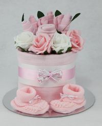 An individually designed hand crafted baby clothes flower bouquet single tier nappy cake which is available in a choice of three colours   Contents:   7 Pampers