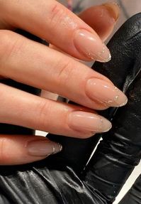 Add a hint of glamour to your nails with this nude manicure, featuring fine glitter gold tips. The subtle shimmer and natural color create a timeless yet playful design perfect for weddings or celebrations.