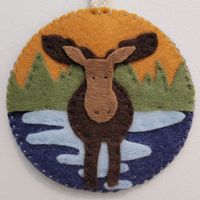 This medallion / ornament was designed to capture the Muskoka spirit and features a Muskoka lake landscape and moose.  This item was handmade in Muskoka, Canada. Please allow for slight variations as this item is handmade and stitched. Size: 3.5" diameter. Please message if you would like a larger/smaller size so this can be discussed.  This medallion / ornament is not stuffed and lays flat.  Please note that colours may vary slightly due to the nature of the felt.  This item is for decorative p