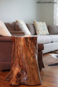 a wooden table sitting in front of a couch on top of a hard wood floor