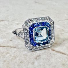 Art Deco Style Handcrafted Platinum 1.05 Carat Aquamarine, Sapphire & Diamond Halo Ring - WeilJewelry Blue Emerald Cut Halo Ring, Blue Art Deco Diamond Ring With Accents, Blue Art Deco Diamond Ring With Center Stone, Art Deco Blue Diamond Ring With Center Stone, Art Deco Blue Diamond Ring With Accents, Blue Emerald-cut Halo Ring With Center Stone, Art Deco Blue Sapphire Ring With Center Stone, Blue Platinum Art Deco Diamond Ring, Blue Diamond Art Deco Ring