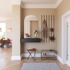 a living room with some chairs and a mirror on the wall next to a shelf