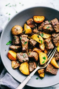 steak and potatoes in a bowl with a fork