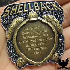 a person holding a metal plaque that says shellback get your coin customized for that special loved one at a gift