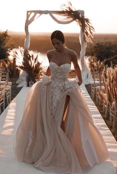 a woman in a wedding dress is walking down the aisle with her long skirt on