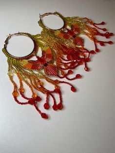 Beautiful Red, orange, and yellow seed bead Phoenix hoop earrings. Festive Beaded Hoop Earrings, Festive Beaded Hoop Earrings With Round Beads, Bohemian Yellow Hoop Earrings, Rainbow Beaded Bohemian Hoop Earrings, Festive Multicolor Beaded Hoop Earrings, Bohemian Beaded Rainbow Hoop Earrings, Bohemian Rainbow Beaded Hoop Earrings, Handmade Red Beaded Hoop Earrings, Red Hoop Earrings For Summer