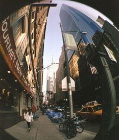 a woman walking down a street next to tall buildings