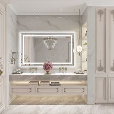 an elegant bathroom with marble counter tops and white cabinetry, along with a chandelier