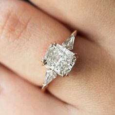 a woman's hand with a diamond ring on it