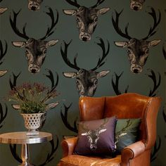 the deer head wallpaper is next to a leather chair