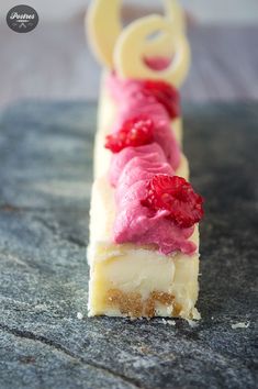 a piece of cake with raspberries on it sitting on top of a table