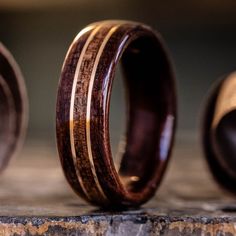 two wooden rings sitting next to each other on top of a stone slab with wood inlays