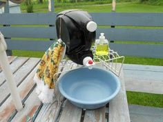 a blue bowl sitting on top of a wooden table next to a bottle of cleaner