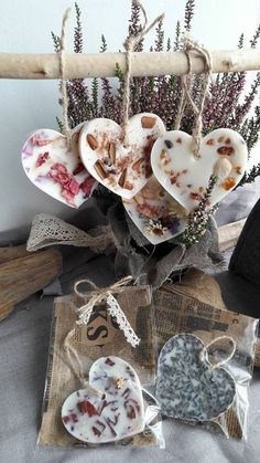 three heart shaped cookies are hanging from a branch