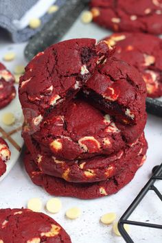 red velvet cookies are stacked on top of each other, with white chocolate chips scattered around them