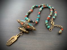 This layer necklace looks great alone or paired with many of my other designs. The little hand and large focal bead is beautifully handcrafted in Nepal from brass with salmon and aqua inlay. This hangs from a strand made with chrysocolla, vintage coral and ancient Roman glass heishi beads. Closes with c clasp and measures 16" with a 2 1/2" chain extension that is finished off with complimentary beads on the end. Rome Antique, Ancient Roman Glass, Roman Glass, Layer Necklace, Heishi Beads, Focal Bead, Bead Necklace, Layered Necklaces, Nepal