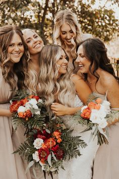 a group of women standing next to each other holding bouquets