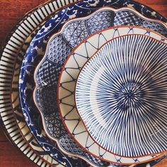 three plates are stacked on top of each other in different patterns and colors, one has an intricate design