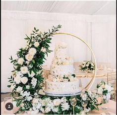 a wedding cake with white flowers and greenery