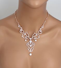 In rose gold plating this necklace is truly beautiful ! Scrolls upon scrolls of cubic zirconia encrusted elegance. At the center of the necklace is a beautiful oval cz stone surrounded by small cz stones. This necklace is perfect for any special occasion gown. Backdrop measures 5 inches. Necklace measures 16 inches and comes with 2 inch extension chain. Matching earrings: https://www.etsy.com/listing/252455207/crystal-bridal-earrings-chandelier Matching bracelet: https://www.etsy.com/listing/525 Elegant Rose Gold Rhinestone Necklace For Wedding, Rose Gold Backdrop, Statement Necklace Wedding, Princess Cut Stud Earrings, Bridal Backdrop Necklace, Bridal Statement Necklace, Backdrop Necklace, Elizabeth Jewelry, Bridal Earrings Chandelier