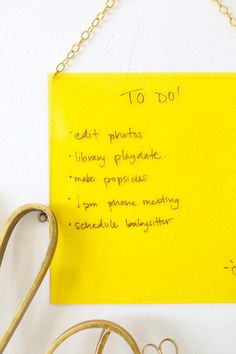 a yellow piece of paper with writing on it next to some scissors and other items