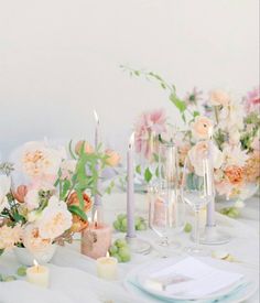 the table is set with flowers and candles