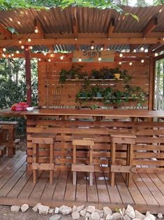 an outdoor bar made out of wooden pallets with lights strung from the roof and above it