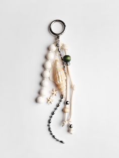 a keychain with an animal and beads hanging from it's side on a white surface