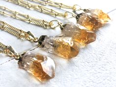 "Gorgeous raw citrine crystals dipped in gold plating! Each dainty crystal measures approximately 3/4\" - 1\" long (see model for size reference). Chains are available in your choice of length: 16\" for an extra short length, 18\" for a standard length, or 20\" for extra length (Model is wearing 18\"). You may also choose your chain finish: Real 14K Gold filled or Gold plated. Finally, you may choose your chain style. All chains are shown in the 3rd photo. Necklace comes in a custom gift pouch, Gold Crystal Necklace With Raw Stone As Gift, Gold Crystal Necklace With Raw Stone For Gifts, Healing Gold Crystal Necklaces, Gold Dainty Crystal Necklace For Healing, Gold Citrine Pendant Crystal Necklace, Gold Citrine Necklace For Healing, Healing Amber Citrine Crystal Necklaces, Gold Citrine Gemstone Crystal Necklace, Gold Citrine Gemstone Crystal Necklaces