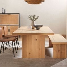 a dining room table with two chairs and a basket hanging from the ceiling