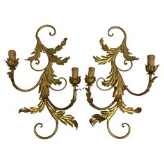 a pair of wall sconces with leaves and scrolls