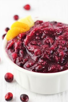 a white bowl filled with cranberry sauce on top of a table