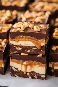 there are many pieces of chocolate and nuts on top of each other with caramel drizzle