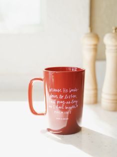 a red coffee mug sitting on top of a table