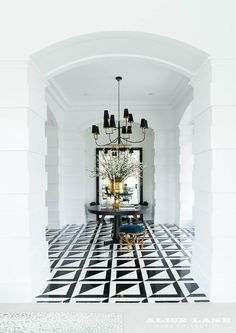 a black and white checkered floor with chandelier in the center is shown