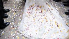 the bride is walking down the aisle in her wedding dress with petals all over it