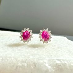 A timeless and classic design, symbolizing love, commitment and wealth. Perfect for everyday wear or dressed up for special occasions. Rubies are said to symbolize the sun, while its glowing hue suggests an inextinguishable flame within the stone. Add a pop of color with our Genuine Ruby and Diamond Solaris Earrings, available in 14k solid white gold and 14k solid yellow gold. Item Specifications: Materials: 14k Solid Gold  Gemstone: Natural Ruby Earring Diameter: 7.5 mm x 6.6 mm Ruby Diameter: Timeless Gemstone Earrings For Formal Occasions, Elegant 14k Gold Gemstone Earrings, Ruby Earrings With Brilliant Cut In Fine Jewelry Style, Fine Jewelry Ruby Earrings With Brilliant Cut, Elegant 14k Gold Earrings With Gemstones, Ruby Earrings Brilliant Cut Fine Jewelry, Luxury Ruby Earrings With Halo Design, Ruby Brilliant Cut Fine Jewelry Earrings, Classic Ruby Earrings With Halo Design