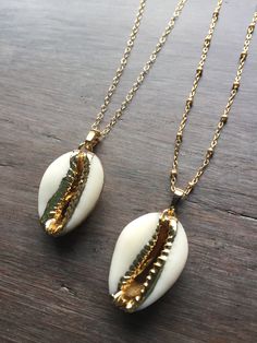 Cowrie Shell Necklace. This real cowrie shell has been dipped in 18k gold. It dangles from a gold-filled chain in your choice of a simple link or satellite chain. Wear it alone or layered for a great boho look. Matching bracelet available: https://www.etsy.com/listing/618535410/cowrie-shell-bracelet-adjustable?ref=shop_home_active_1 Matching earrings available here: https://www.etsy.com/listing/641824355/cowrie-shell-earrings-gold-cowrie-shell?ref=shop_home_active_2 Your cowrie shell necklace wi Shell-shaped Necklace With Adjustable Chain, Handmade Gold Shell-shaped Necklace, Handmade Gold Shell Necklace, Gold Handmade Shell-shaped Necklace, Gold Shell Jewelry With Adjustable Chain, Gold Shell-shaped Bohemian Necklace, Gold Plated Shell Necklace For Gifts, Gold Plated Shell Necklace Gift, Gold Pendant Shell Necklace With Adjustable Chain