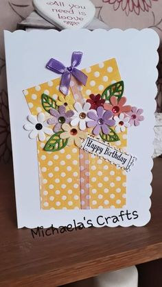 a close up of a card on a table with flowers and polka dotty paper