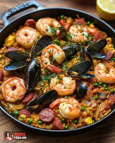 paella with shrimp and mussels in a skillet on a wooden table