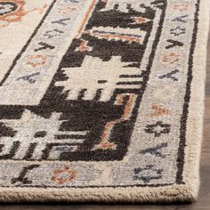 an area rug with various colors and designs on the floor in front of a wooden floor