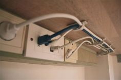 an electrical outlet attached to the ceiling in a room with white cabinets and cupboards