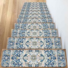 a set of blue and white rugs sitting on top of a wooden stair case