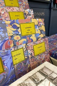 several different types of maps on display in a room with blue and yellow wallpaper